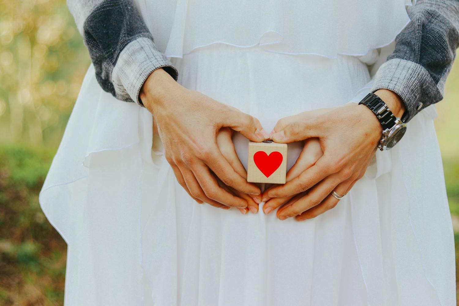 couple holding block with heart shape