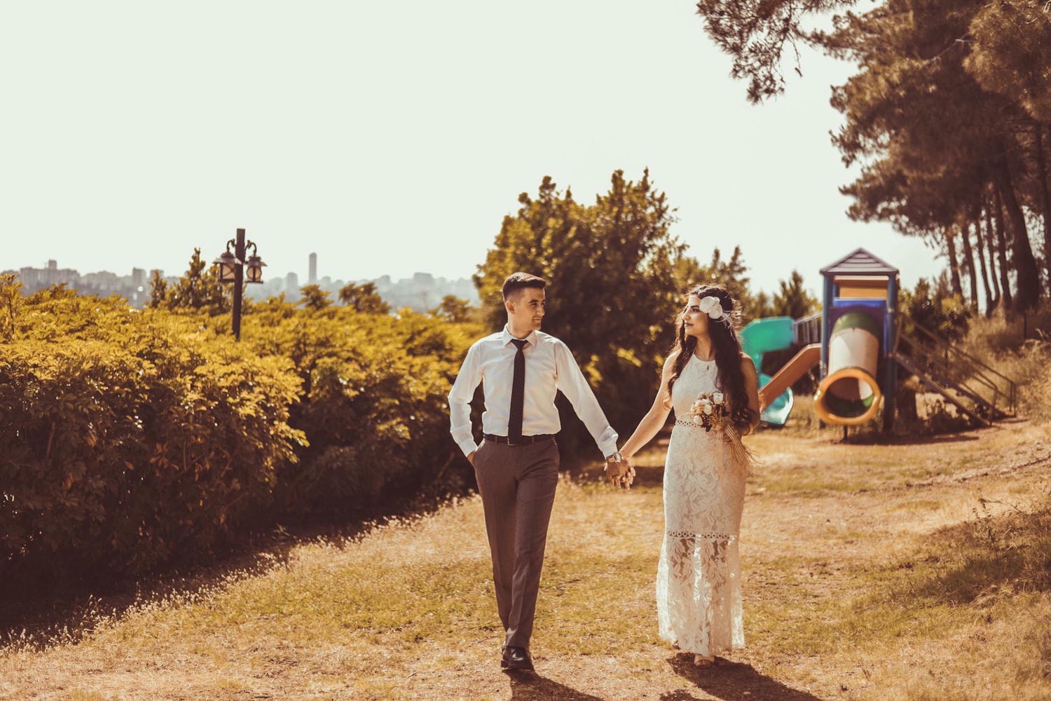 photo of couple holding hands while walking