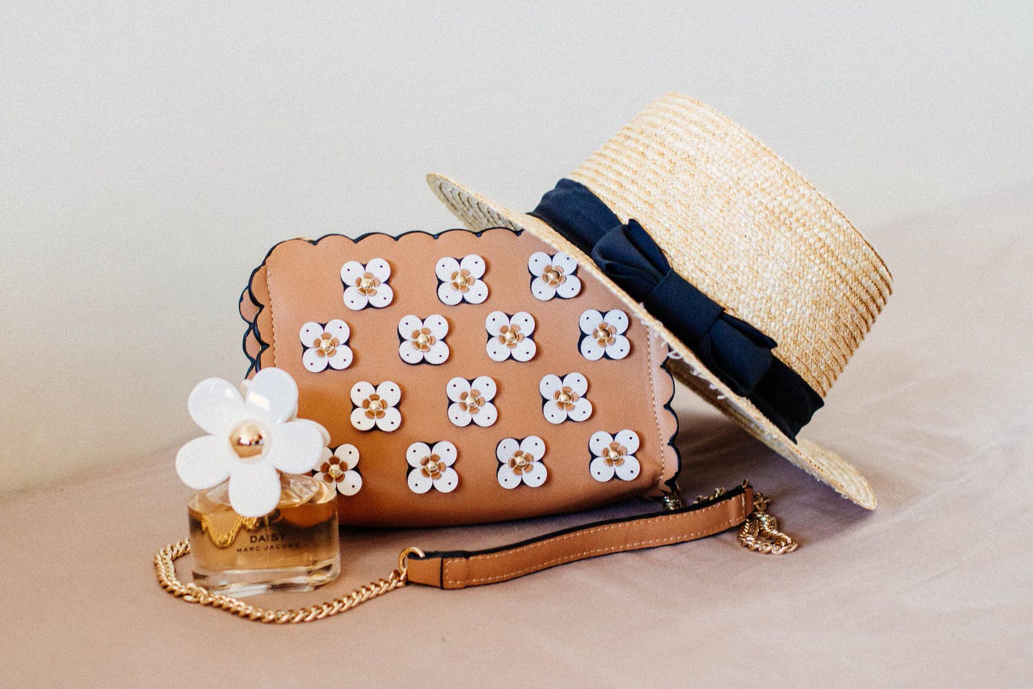 brown sun hat on brown and white floral sling bag