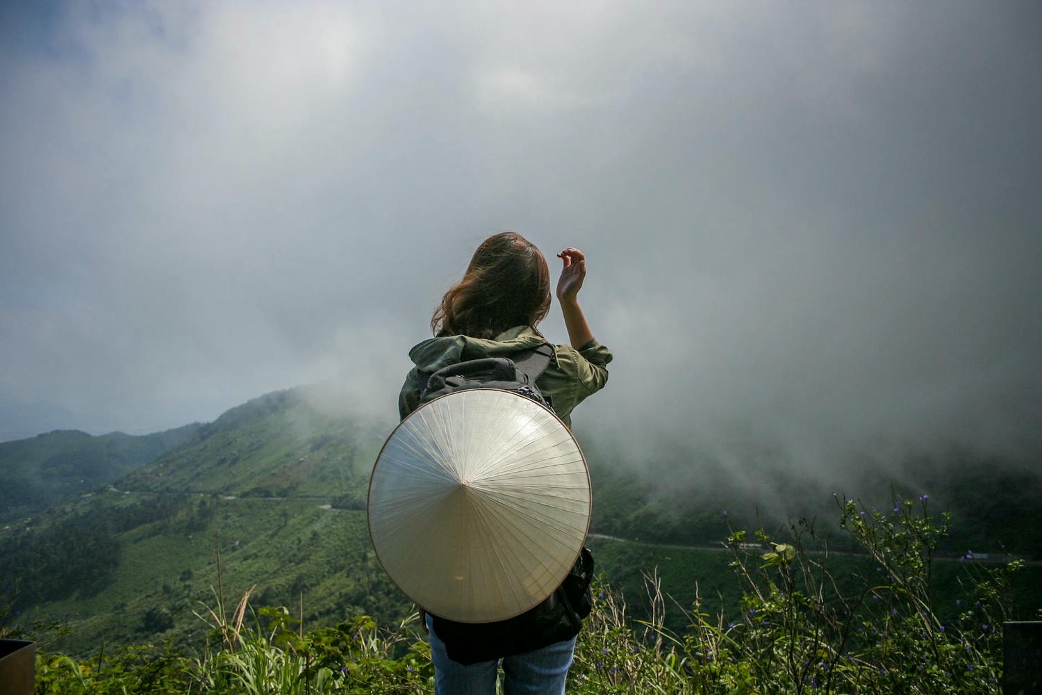 back view of a woman standing with a coolie hat