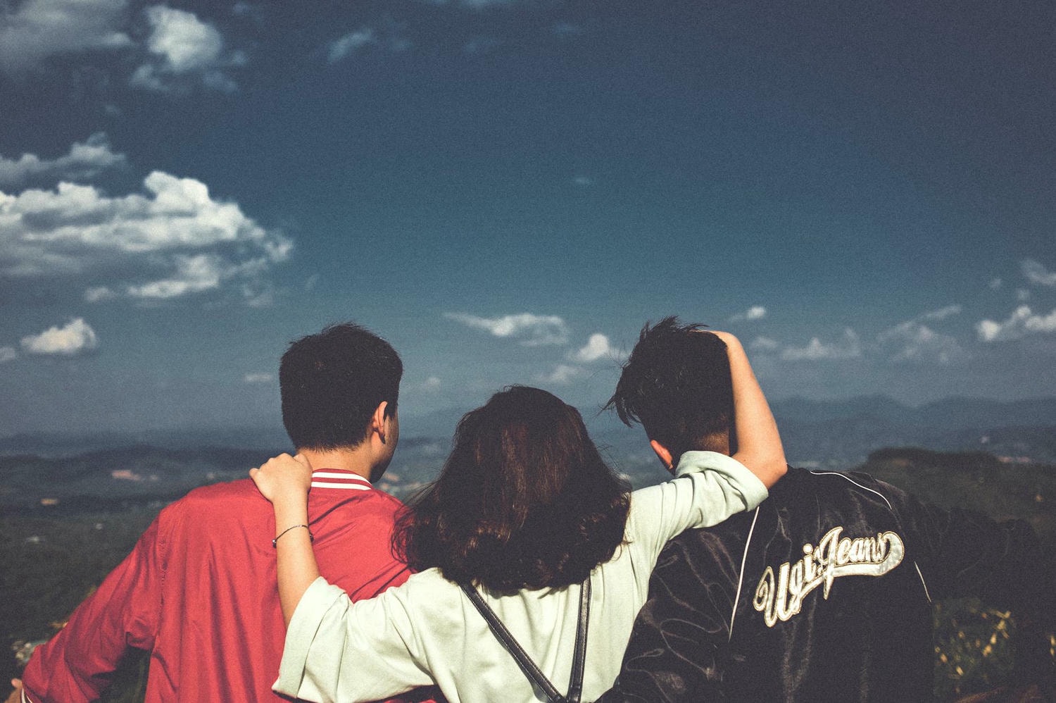 woman between men facing mountains