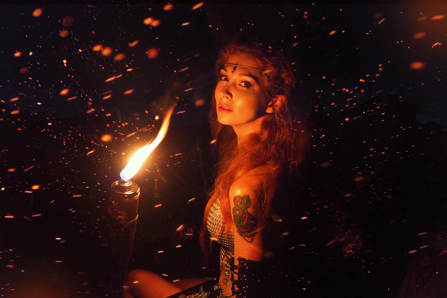 woman sitting beside lighted torch