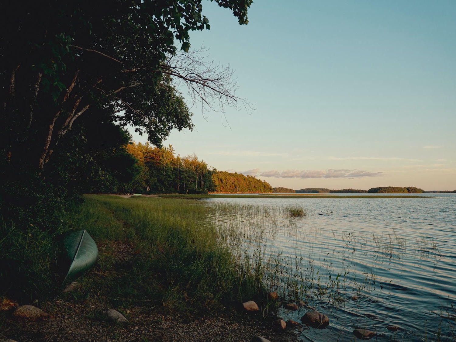 tranquil lakeside view at sunset with canoe