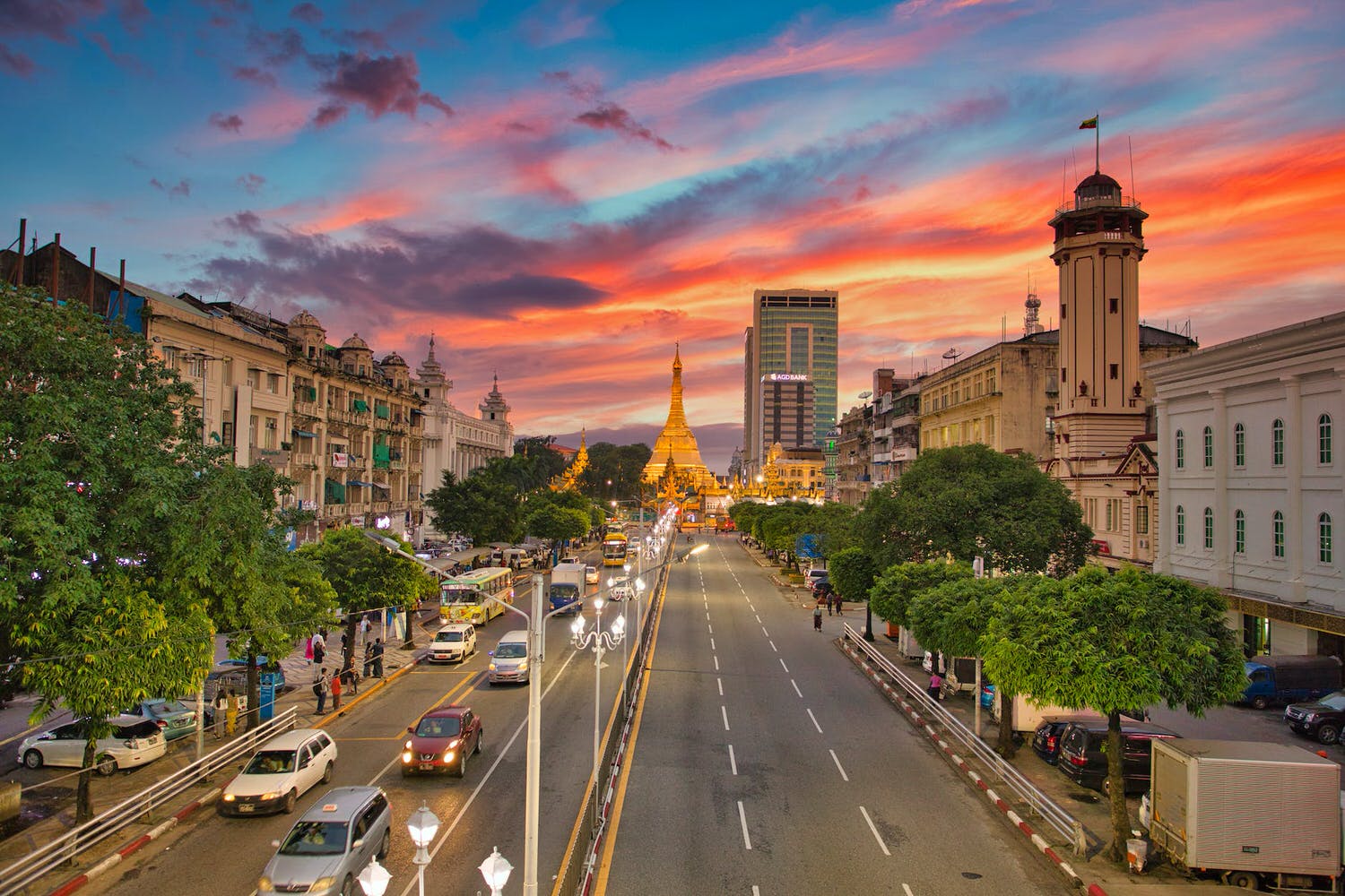 city streets in myanmar with view of pule pagoda during sunset