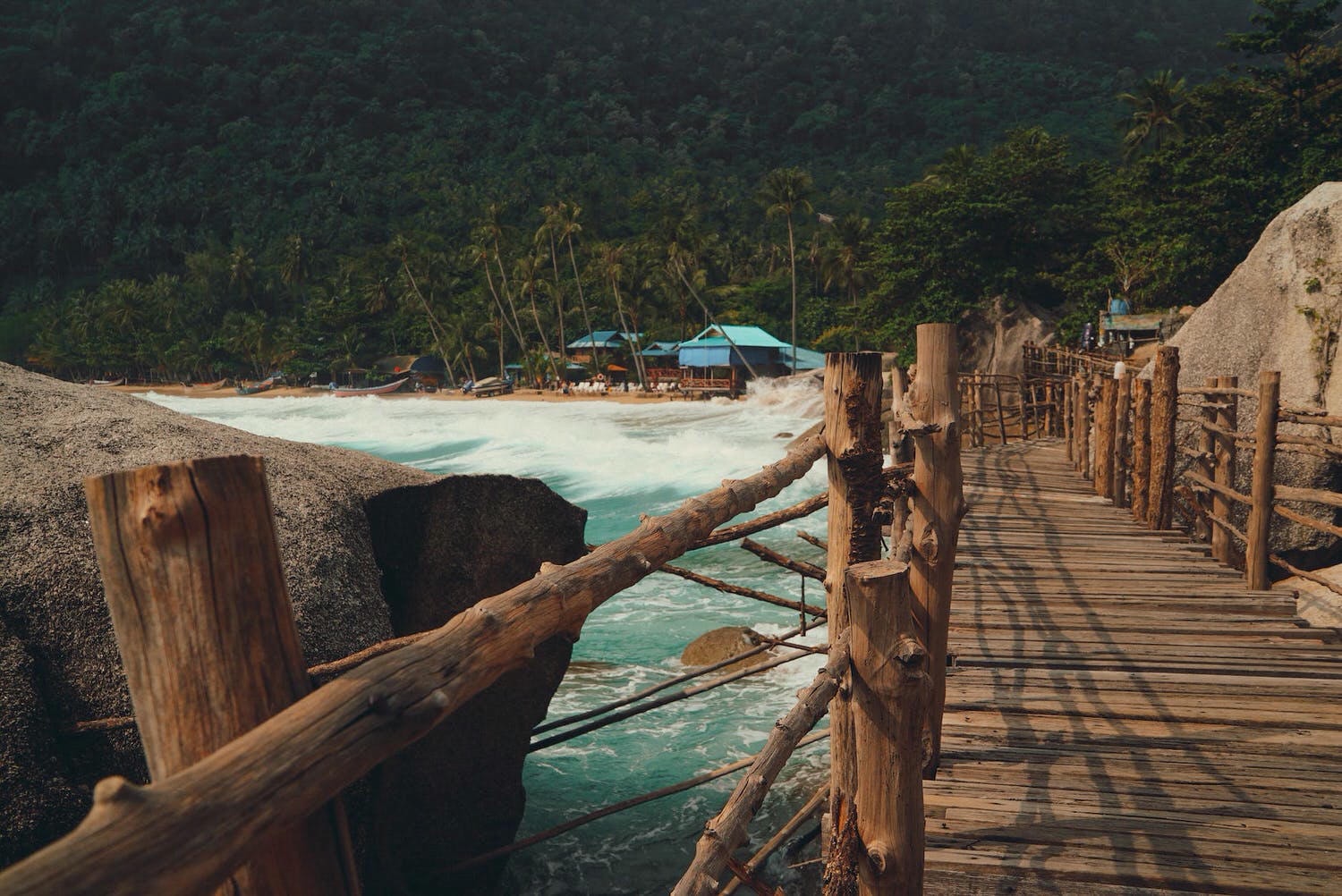 brown wooden footbridge beside body of water