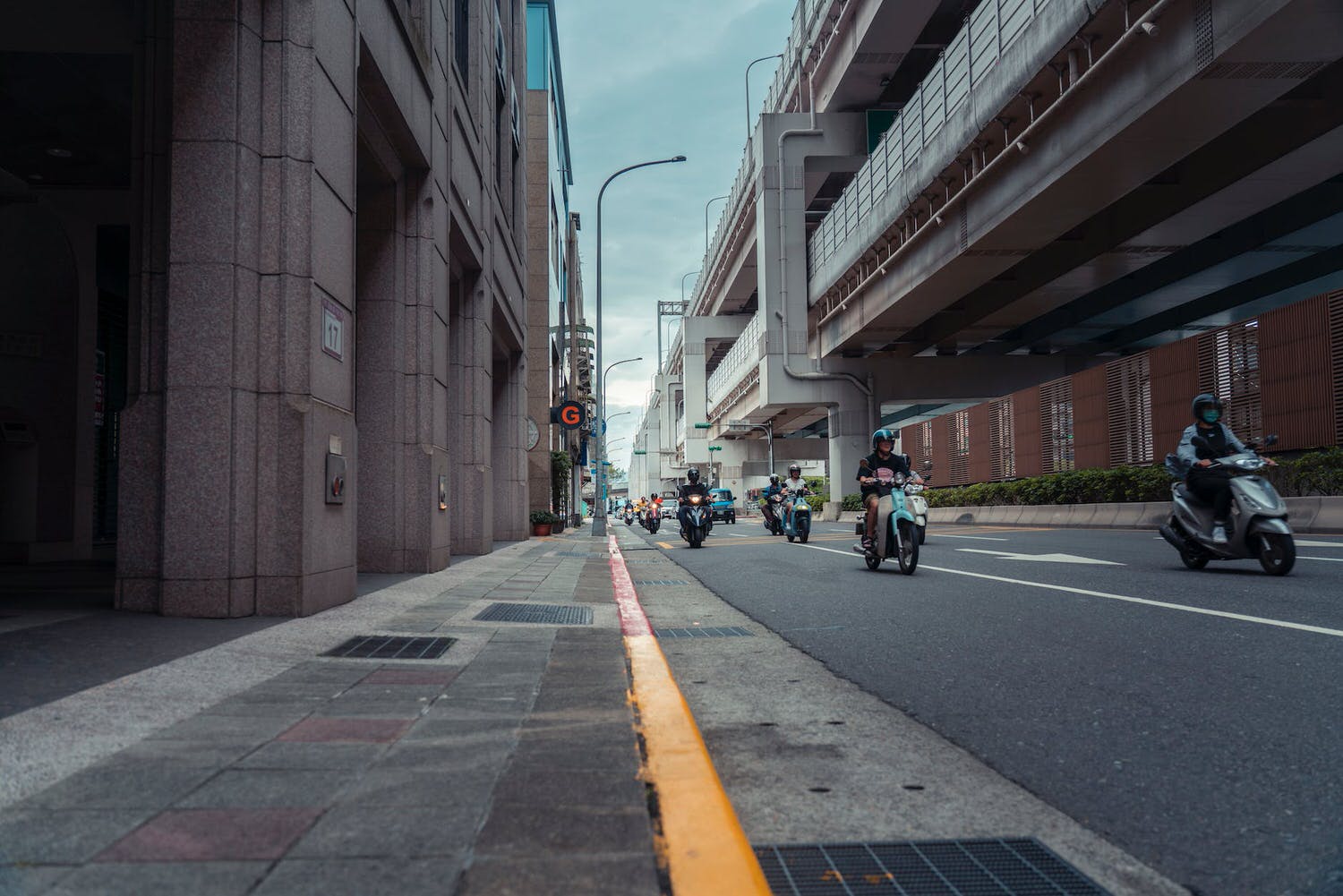 a group of people riding motorcycles down a city street