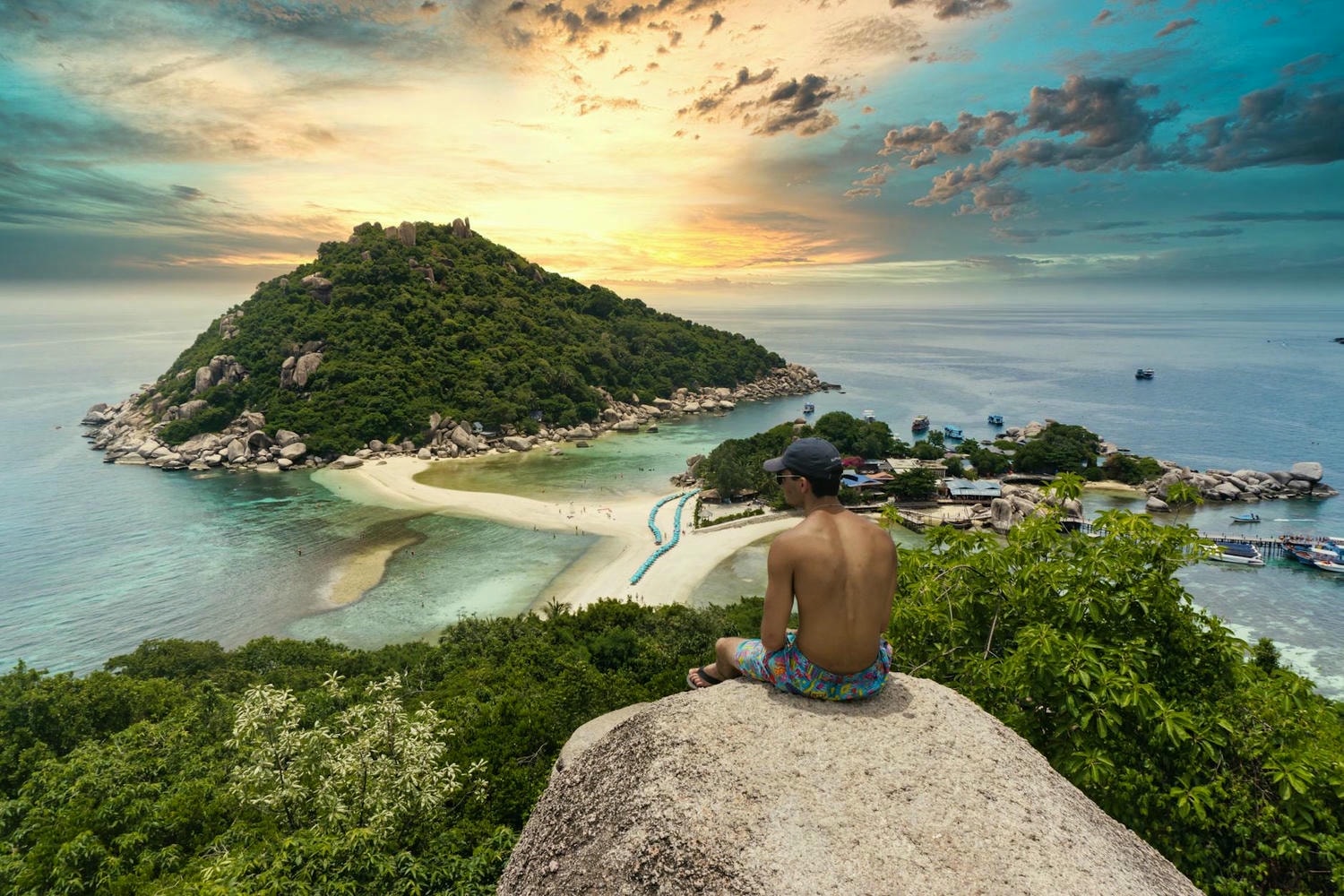 shirtless man sitting on a rock